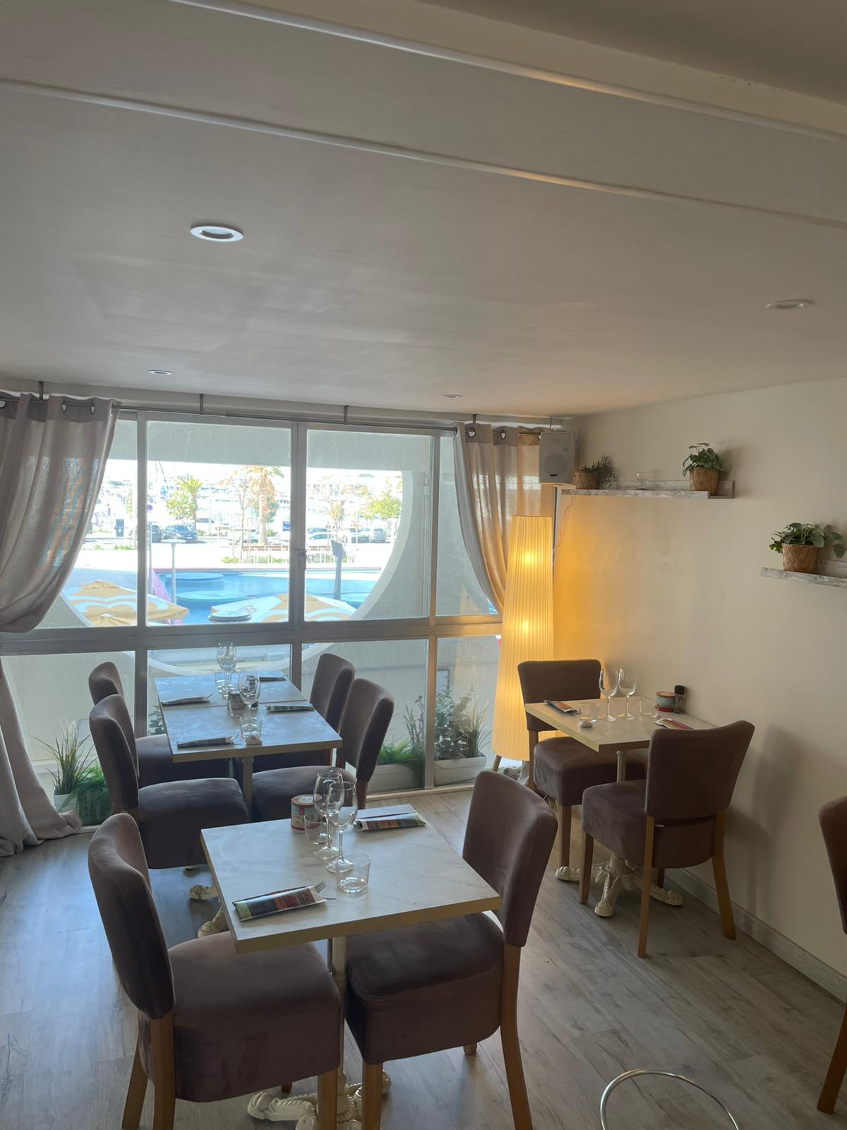 La salle intérieure de Bellano Beach avec mur teal et lampes cuivrées